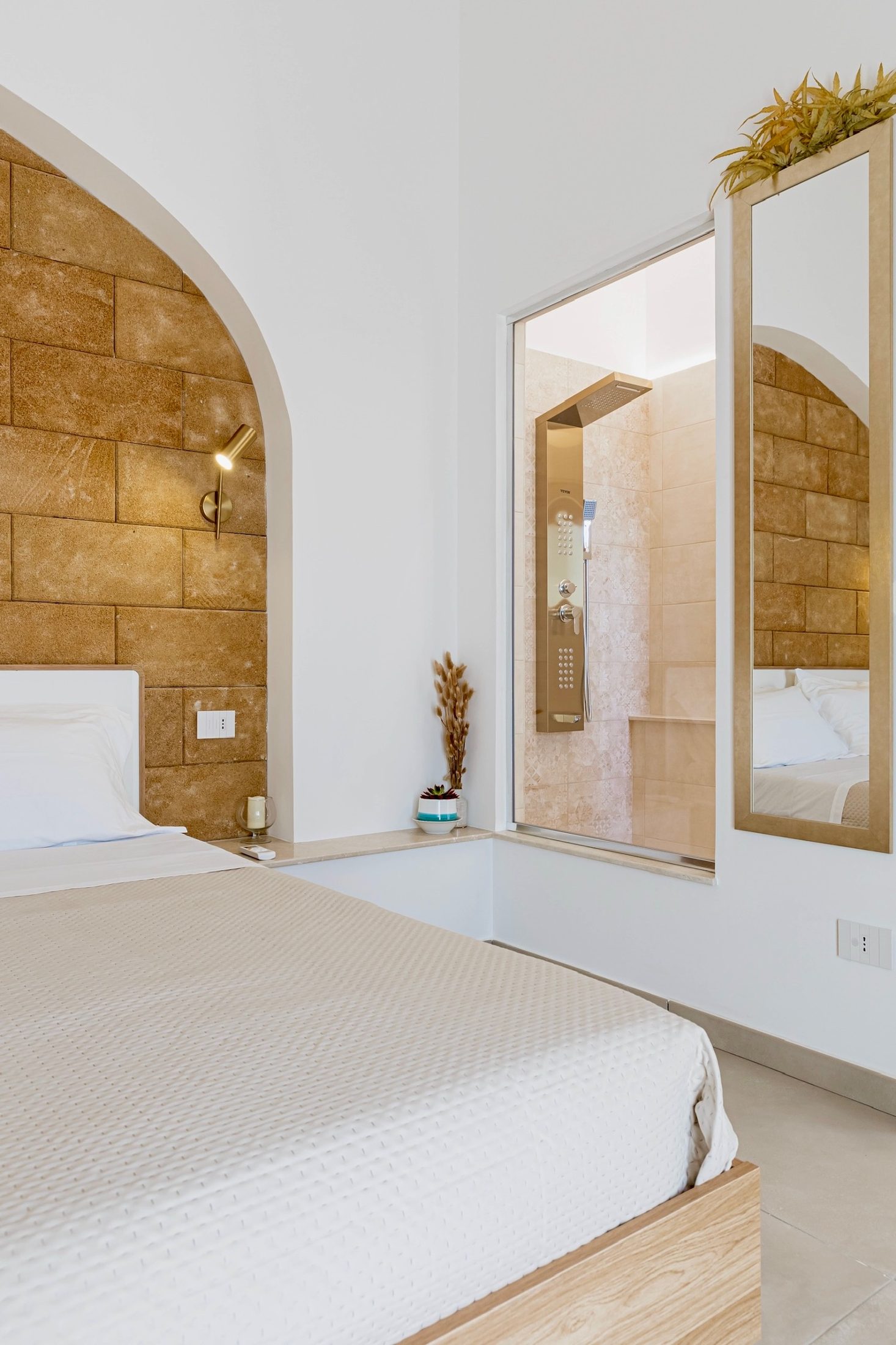 Il letto e la parete vetrata verso il bagno